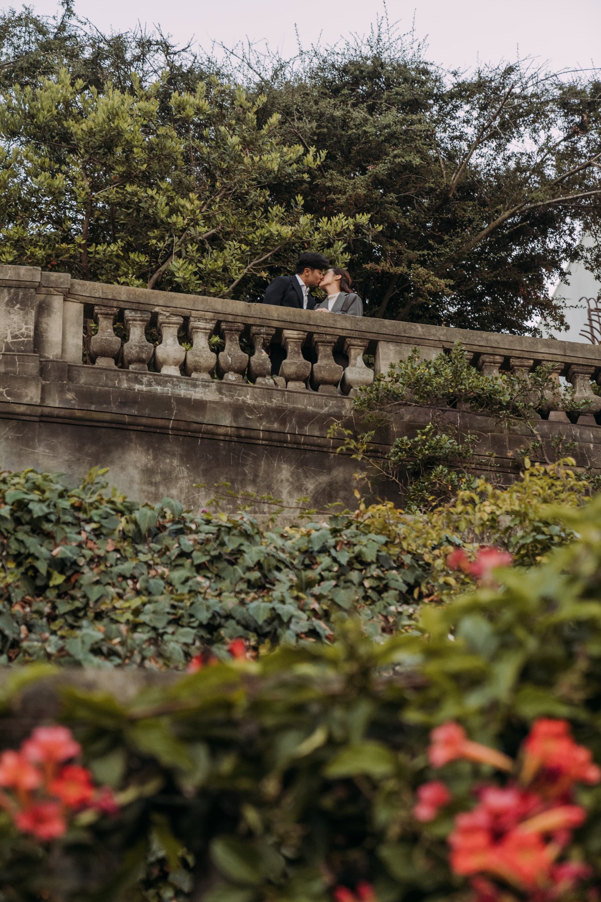 ethan and tina kissing on a balustrade above san francisco